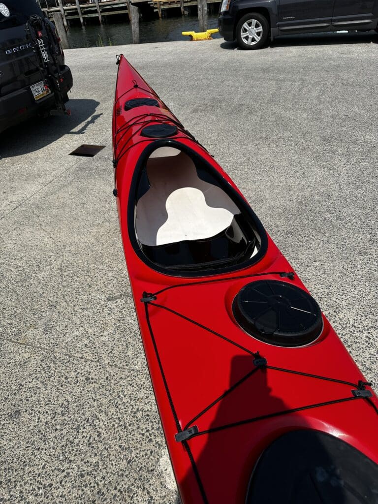 Red sea kayak on dockside pavement
