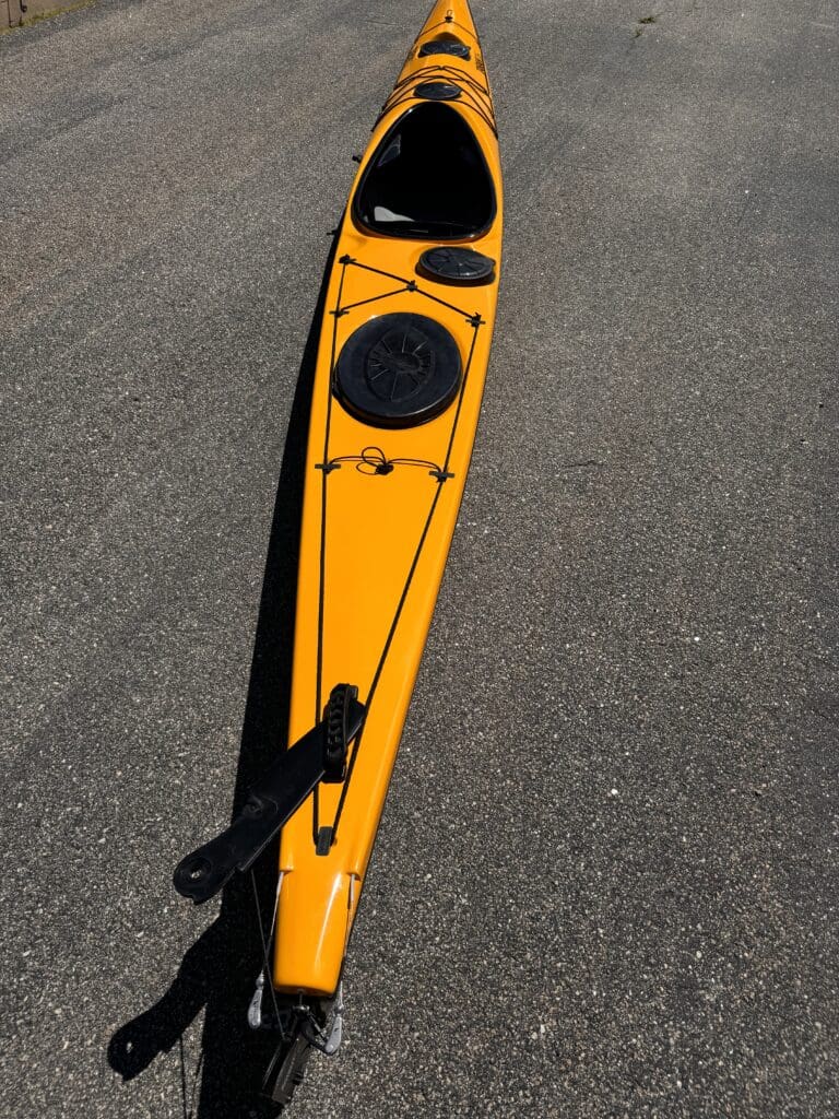 Bright yellow kayak on asphalt pavement