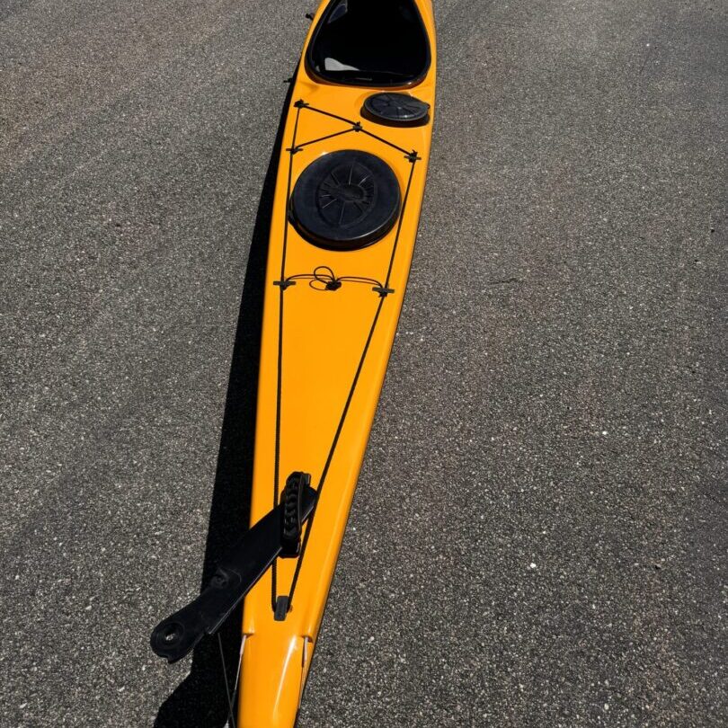 Bright yellow kayak on asphalt pavement